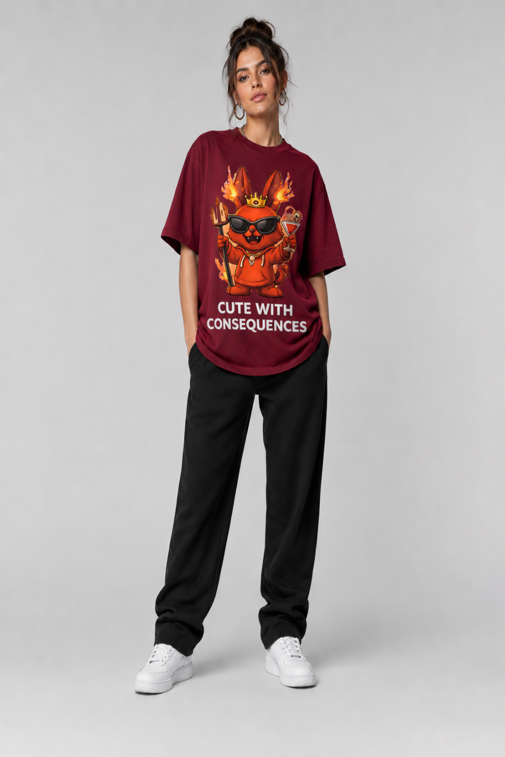 Person wearing a maroon t-shirt with a graphic design and text, standing against a plain background